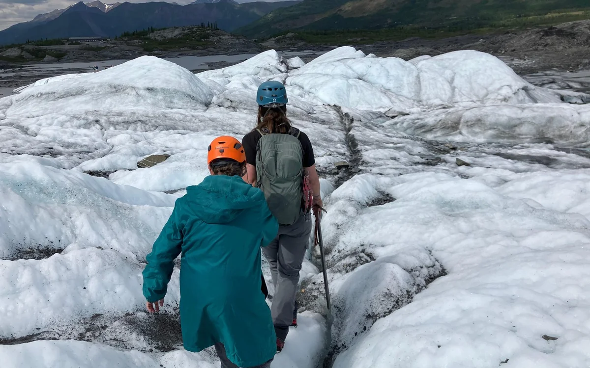 Hikers in ice cleats walking on the surface of the Matanuska Glacier in Alaska