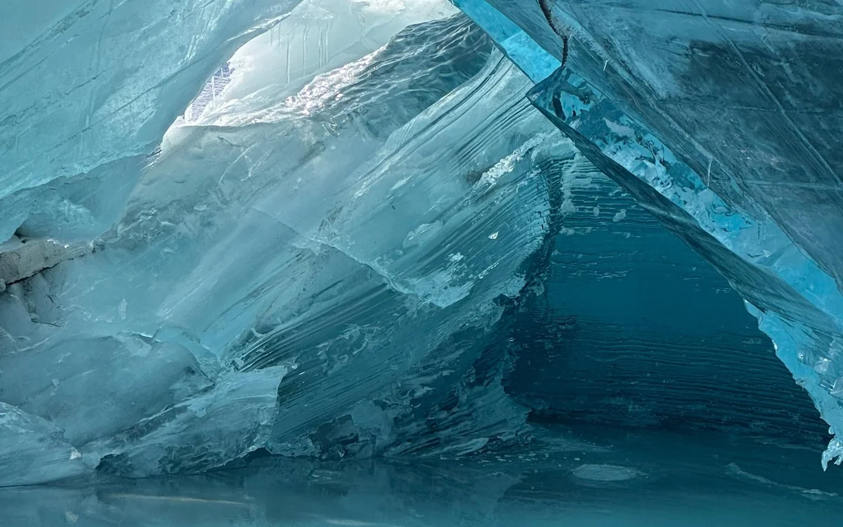 Ice cleats being strapped onto a boot at the edge of a glacier in Alaska